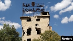 Алеппо в июне 2013 года. Плакат на здании гласит: "БААС, арабизм, единство, свобода, социализм"