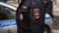 RUSSIA -- A woman wearing a protective gear follows a policeman detaining her for throwing a stone and damaging a municipal vehicle disinfecting a street in downtown Moscow, October 22, 2020