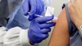 U.K. -- A subject receives a shot in the first-stage safety study clinical trial of a potential vaccine by Moderna for COVID-19, the disease caused by the new coronavirus, at the Kaiser Permanente Washington Health Research Institute in Seattle, March 16,
