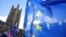 U.K. -- Anti-Brexit demonstrators wave flags outside the Houses of Parliament in London, Britain, November 13, 2018. 