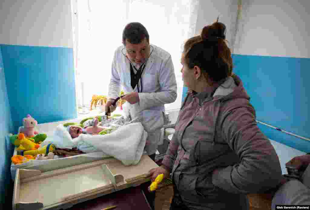 Дмитрий Розумий осматривает ребенка. 51-летний семейный доктор раньше работал хирургом-онкологом, но ушел, заявив, что сокращение бюджета повышает смертность