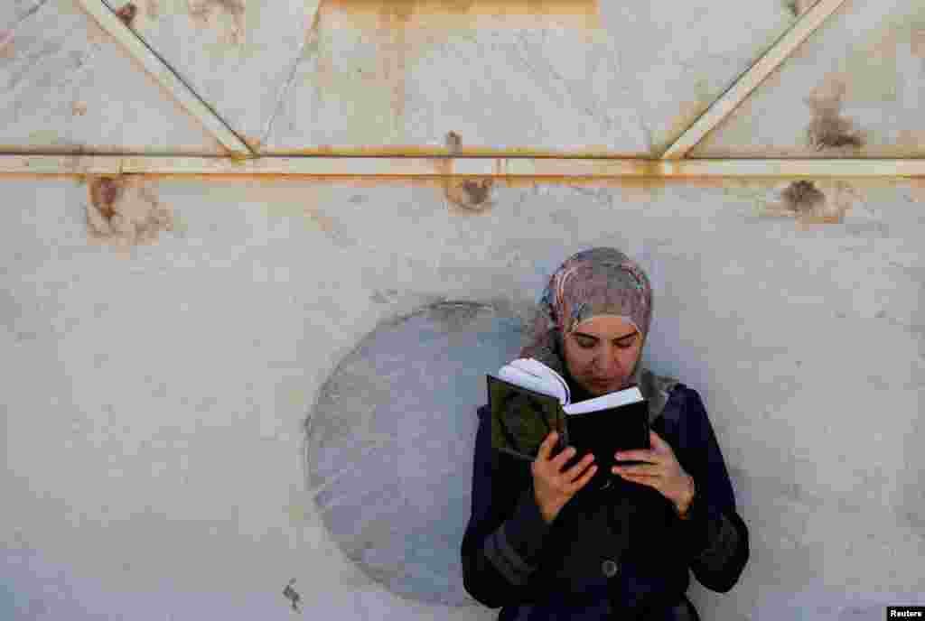 Принимать пищу разрешается только после заката во время ифтара, ритуала вечернего разговления На фото &ndash; палестинская женщина читает Коран в Иерусалиме. 10 июня 2016