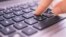 Close up on fingers texting on a computer keyboard