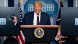 US -- President Donald Trump holds a mask as he speaks during a news conference at the White House, Tuesday, July 21, 2020, in Washington. (AP Photo/Evan Vucci)