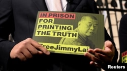 Сын Джимми Лая держит табличку с призывом освободить его отца перед зданием резиденции премьер-министра Великобритании в Лондоне, сентябрь 2025 года