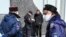 Russia -- Rostov-on-Don. A Russian police officer checks the documents of a pedestrian as Cossacks stand nearby as they patrol a district