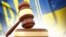 UKRAINE – Wooden gavel and flag of Ukraine as background  