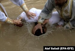 Православные паломники принимают обряд Крещения в реке Иордан. Январь 2018 года. Фото: EPA-EFE