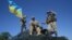UKRAINE – US soldiers (C and R) and an Ukrainian soldier climb on an armored military vehicle as they attend the joint military exercises 'Rapid Trident 2016' at the Yavoriv training ground, near the western Ukrainian city of Lviv, 04 July 2016