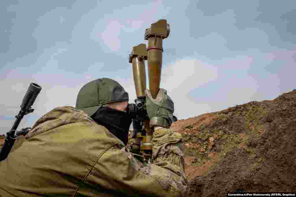 Боец &quot;Азова&quot; смотрит на вражеские позиции. Село Широкино в Донецкой области. 18 апреля 2015&nbsp;