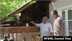 Komil Muminov shows Current Time Asia correspondent Anushervon Aripov damage to the roof of his house in the Tajik village of Somoniyon, following the April 28-April 29, 2021 fighting with Kyrgyzstan.