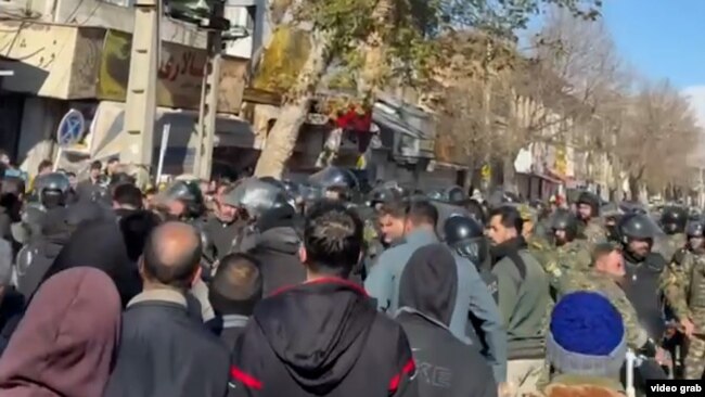 Протестующие и силовики во время протестов в городе Керманшах на западе Ирана, 30 декабря 2025 года