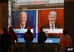 Джо Байден и Дональд Трамп на экране во время подведения итогов выборов президента США в ноябре 2020 года. Фото: AFP