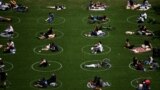 U.S. -- People are seen practising social distancing in white circles in Domino Park, during the Covid-19 pandemic on May 17, 2020 the in Brooklyn borough of New York City. (Photo by Johannes EISELE / AFP)