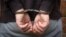 Criminal in handcuffs arrested for crimes. Close-up of a criminal hand in handcuffs