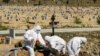RUSSIA -- Cemetery workers wearing protective gear bury a coronavirus victim at a cemetery on the outskirts of St. Petersburg, May 6, 2020