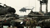 Poland -- A Polish Army 'Mil Mi-17' transport helicopter (C) hovers behind troops preparing for the NATO military exercise 'Dragon-15' at the Land Forces Training Centre 'Orzysz' in the Bemowo Piskie village, Masuria region, October 16, 2015