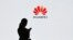 (FILES) In this file photo taken on March 6, 2019 a staff member of Huawei uses her mobile phone at the Huawei Digital Transformation Showcase in Shenzhen, China's Guangdong province. - US internet giant Google, whose Android mobile operating system power