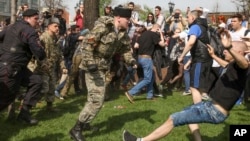 A "Cossack" assaults an antigovernment protester during clashes in Pushkin Square in Moscow on May 5.