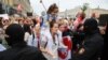 A woman carrying a girl confronts riot police during a women's march in Minsk against election fraud and police violence on August 29, 2020. 