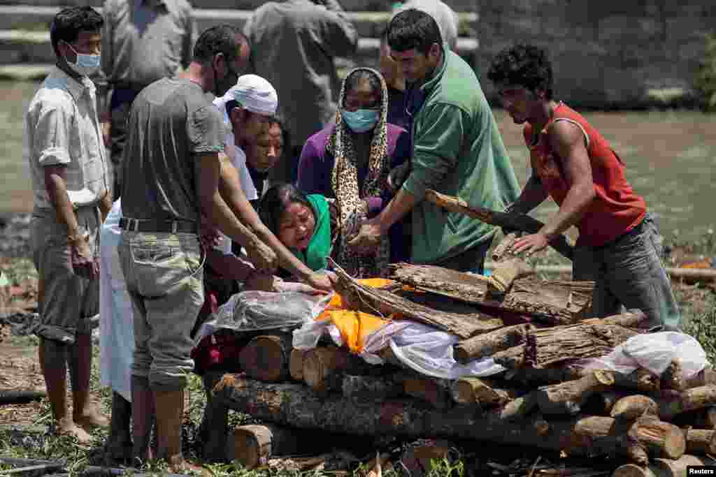 Женщины оплакивают жертв землетрясения перед погребением в Катманду, Непал