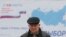 RUSSIA -- A man walks near a board, which informs of the upcoming presidential election, in a street in Stavropol, Russia February 5, 2018