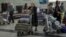 Turkmenistan. People, including passengers of a flight from the Turkmen capital Ashgabat, gather in the baggage claim area upon their arrival at Almaty International Airport