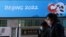 China -- People walk past a banner with a sign of Beijing 2022 Winter Olympic Games, 100 days ahead of the opening of the event, in Beijing, China October 27, 2021. REUTERS/Tingshu Wang