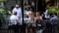 U.S. -- A server converses with people at a crowded restaurant  amid a coronavirus disease (COVID-19) outbreak in Birmingham, Michigan, U.S., June 30, 2020.  REUTERS/Emily Elconin
