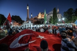 Люди возле Святой Софии в Турции скандируют лозунги и размахивают государственным флагом, 10 июля 2020 года. Фото: AFP