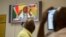 SOUTH AFRICA -- People at the Parliamentary Visitors Centre watch a television broadcast of South African president Jacob Zuma at the parliament, in Cape Town, February 14, 2018