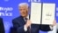 US President Donald Trump holds a signed founding charter at the "Board of Peace" meeting during the World Economic Forum (WEF) annual meeting in Davos on January 22, 2026.
