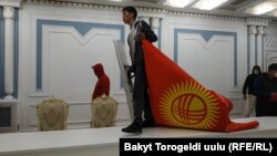 A protester carries the Kyrgyz flag inside a seized government building in Bishkek on October 6, 2020.