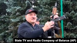 Alyaksandr Lukashenka displays a Kalashnikov-type rifle in Minsk on August 23, 2020.