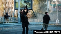 Полицейский стреляет в беспилотник-камикадзе, который российская армия запустила по украинской столице. Киев, 17 октября 2022 года
