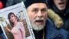 UKRAINE -- An Orthodox priest holds a picture showing murdered Ukrainian lawyer Iryna Nozdrovska as he takes part in a rally outside the Kiev police headquarters on Junuary 2, 2018