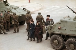 Civilians in Baku walk between a pair of Soviet tanks on January 28, 1990.