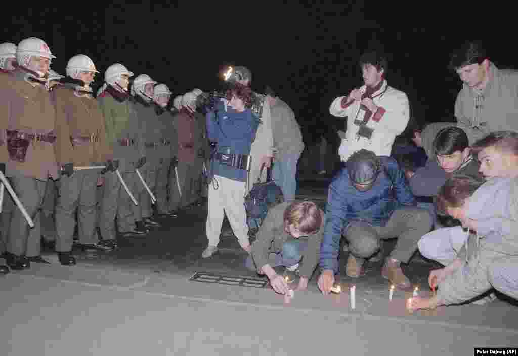 Протестующие зажигают свечи у полицейского кордона, который не дал им перейти мост, 21 ноября