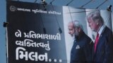 INDIA -- An Indian worker installs a giant hoarding welcoming U.S. President Donald Trump ahead of his visit, in Ahmadabad, February 20, 2020