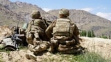US -- (FILES) In this file photo taken on June 6, 2019 US soldiers look out over hillsides during a visit of the commander of US and NATO forces in Afghanistan General at the Afghan National Army (ANA) checkpoint in Nerkh district of Wardak province. - An