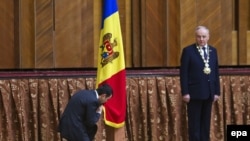 Новый молдавский премьер Кирилл Габурич целует молдавский флаг 