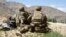 US -- (FILES) In this file photo taken on June 6, 2019 US soldiers look out over hillsides during a visit of the commander of US and NATO forces in Afghanistan General at the Afghan National Army (ANA) checkpoint in Nerkh district of Wardak province. - An