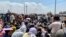 Afghan people gather along a road as they wait to board a U S military aircraft to leave the country, at a military airport in Kabul on August 20, 2021 days after Taliban's military takeover of Afghanistan. (Photo by Wakil KOHSAR / AFP)