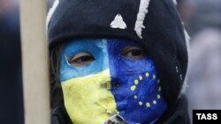 Ukraine -- A demonstrator wears a facemask painted in EU and Ukrainian national colours during a mass rally called For European Ukraine in central Kyiv, November 24, 2013