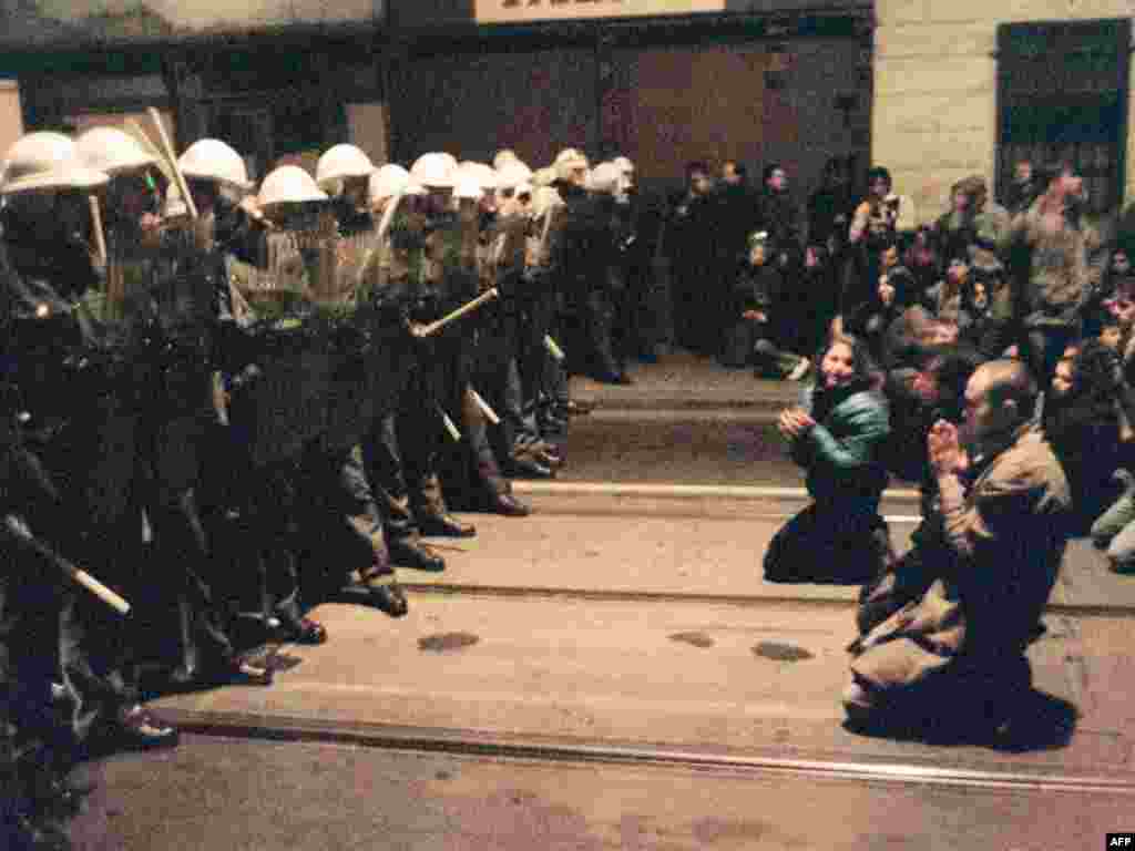 Протестующие стоят на коленях перед полицией 19 ноября. Власти тоже применили силу