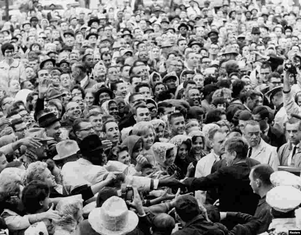 Президент Джон Ф. Кеннеди приветствует толпу во время демонстрации в Форт-Уорте, штат Техас утром 22 ноября 1963 года.