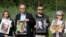 LITHUANIA -- Reporters Without Borders chief Christophe Deloire (2ndL) poses with a photo of detained Belarus journalist Roman Protasevich while other activists pose with photos of other detained Belarusian journalists to protest against the arbitrary det