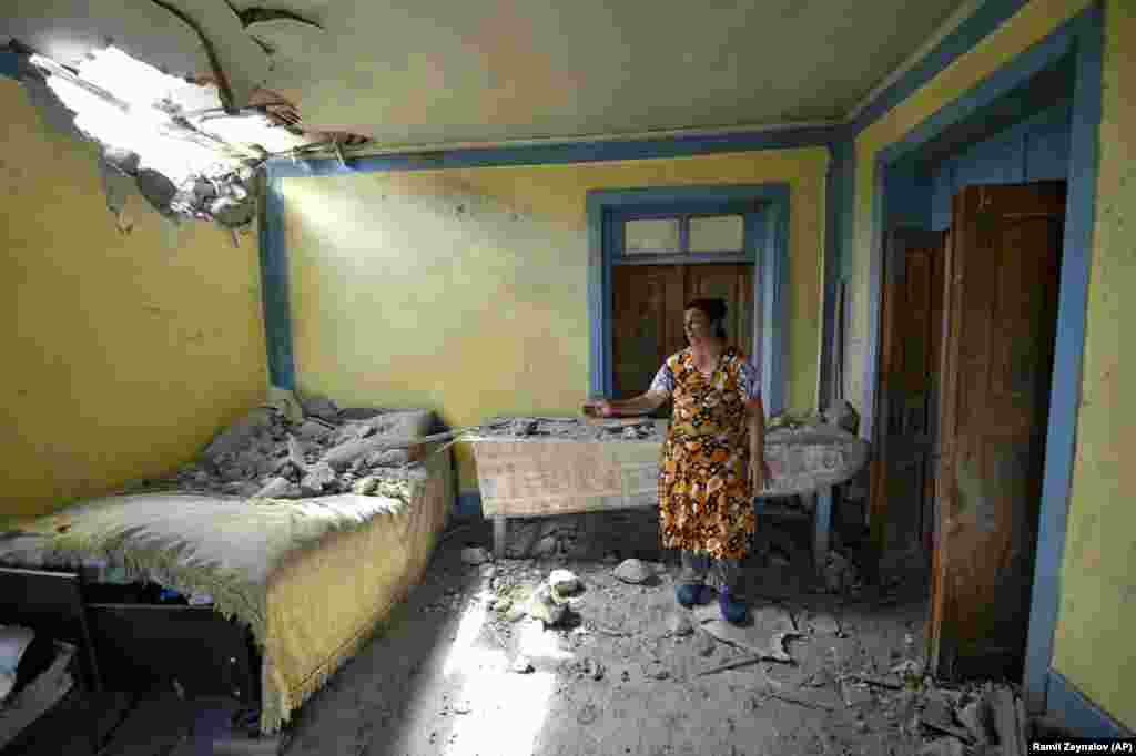 Женщина показывает повреждения в своем доме после обстрела армянскими войсками Товузского района Азербайджана, вторник, 14 июля 2020 года