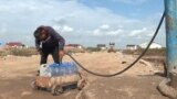 Kazakhstan -- a local resident of Astana fills bottles with water because of the lack of public infrastructure