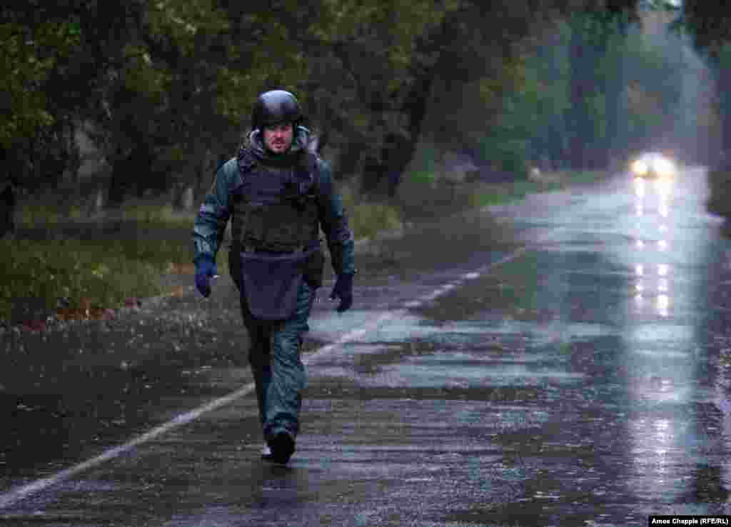 Как только затихает дождь и гул минометов, ван Хелтен идет к краю дороги, чтобы проверить, как выглядит мурал